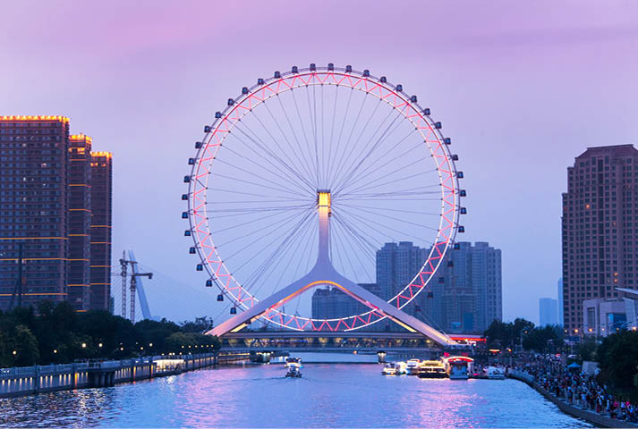 TIANJIN, CHINA - JUL 04, 2016: Tianjin is a metropolis in northern coastal China, tall giant Ferris wheel built above the Yongle Bridge, over the Hai River in Tianjin. JULY 04, 2016